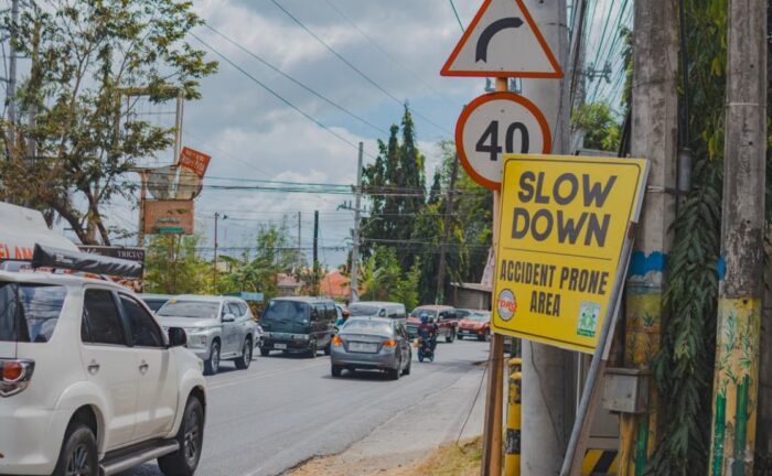Heavy urban traffic on a city street with visible road signs