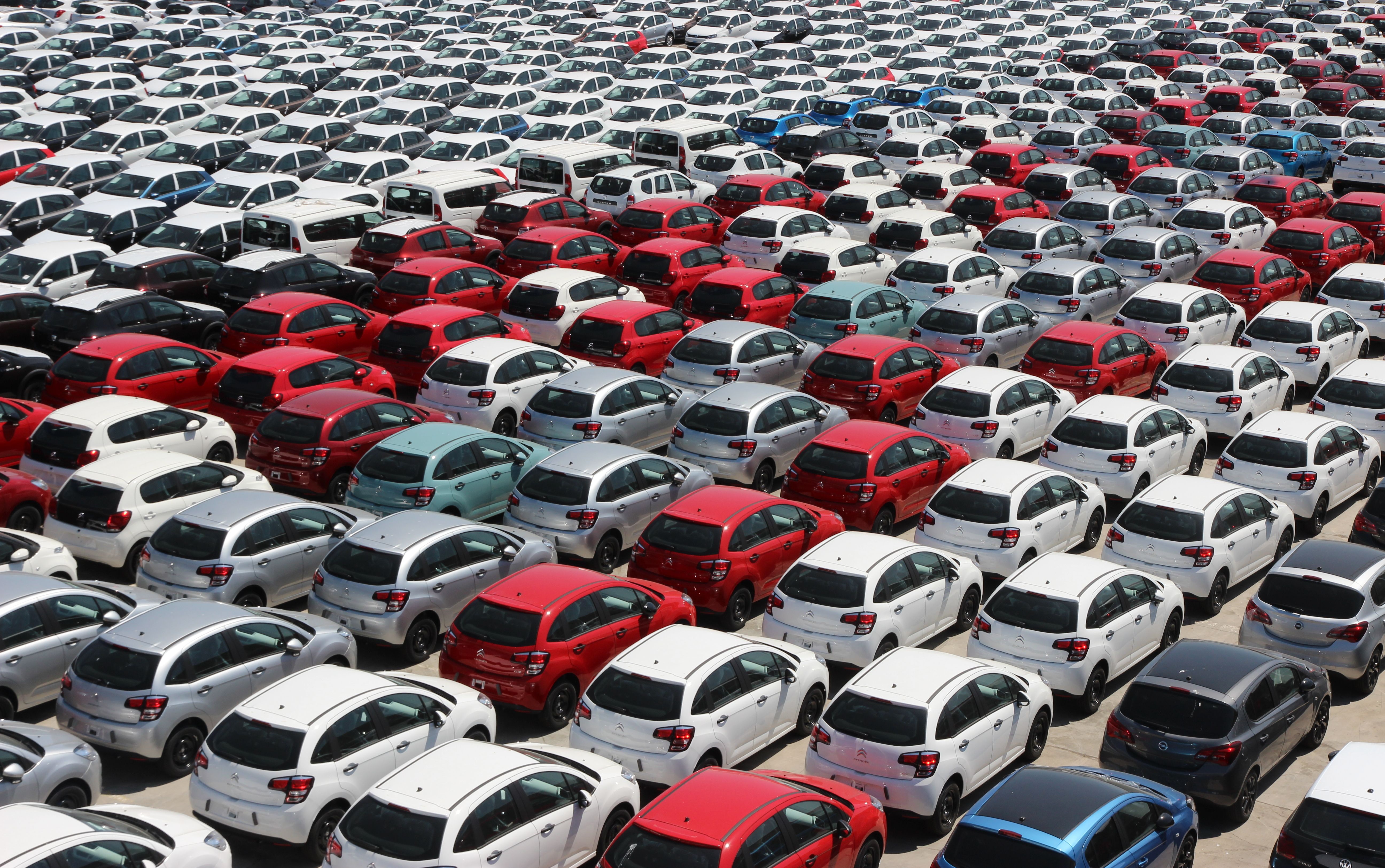 Rows of parked cars in a large lot, representing rental vehicle staging and pickup areas.