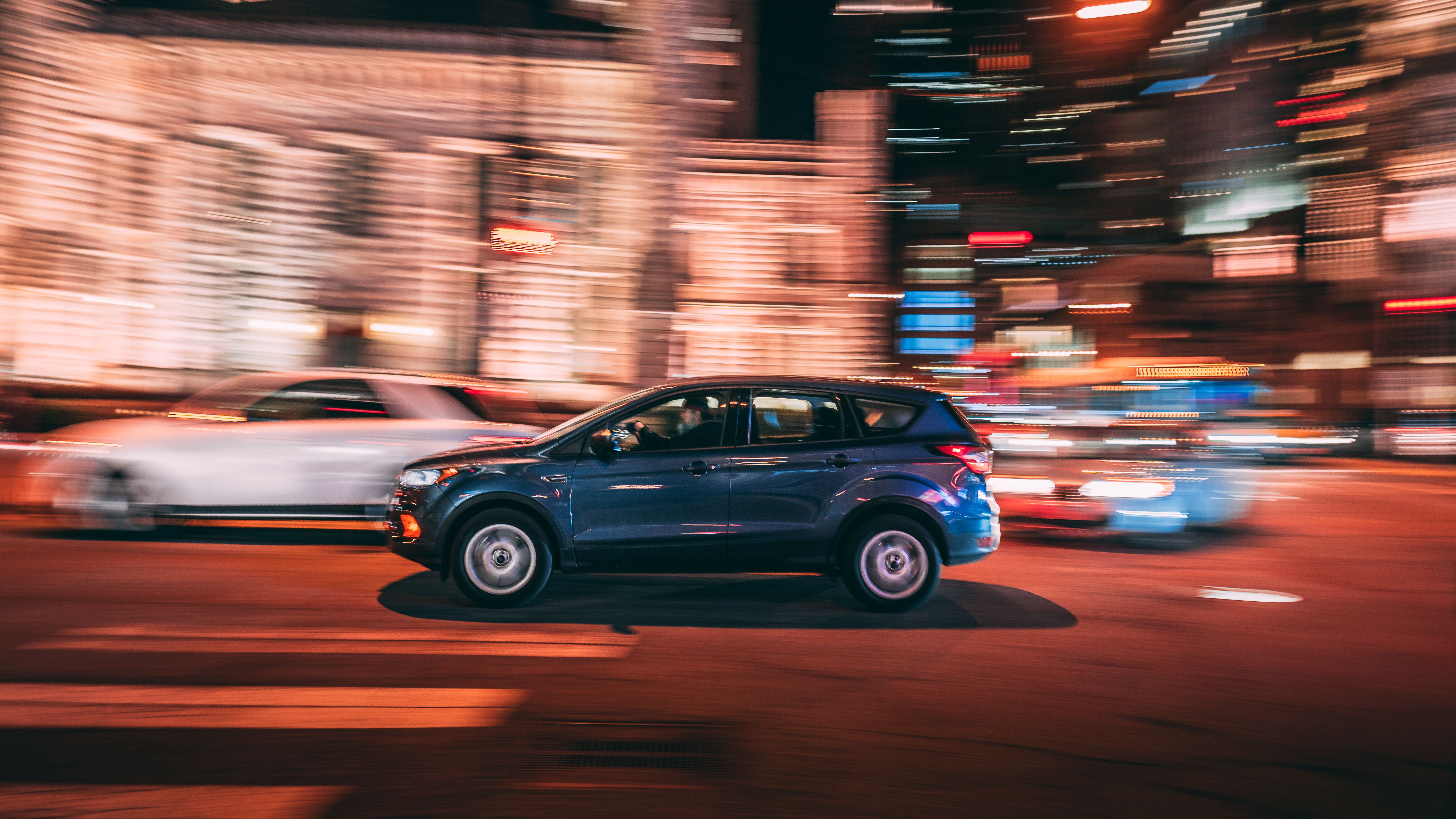 SUV moving quickly through nighttime Chicago traffic, illustrating elevated risks after dark.