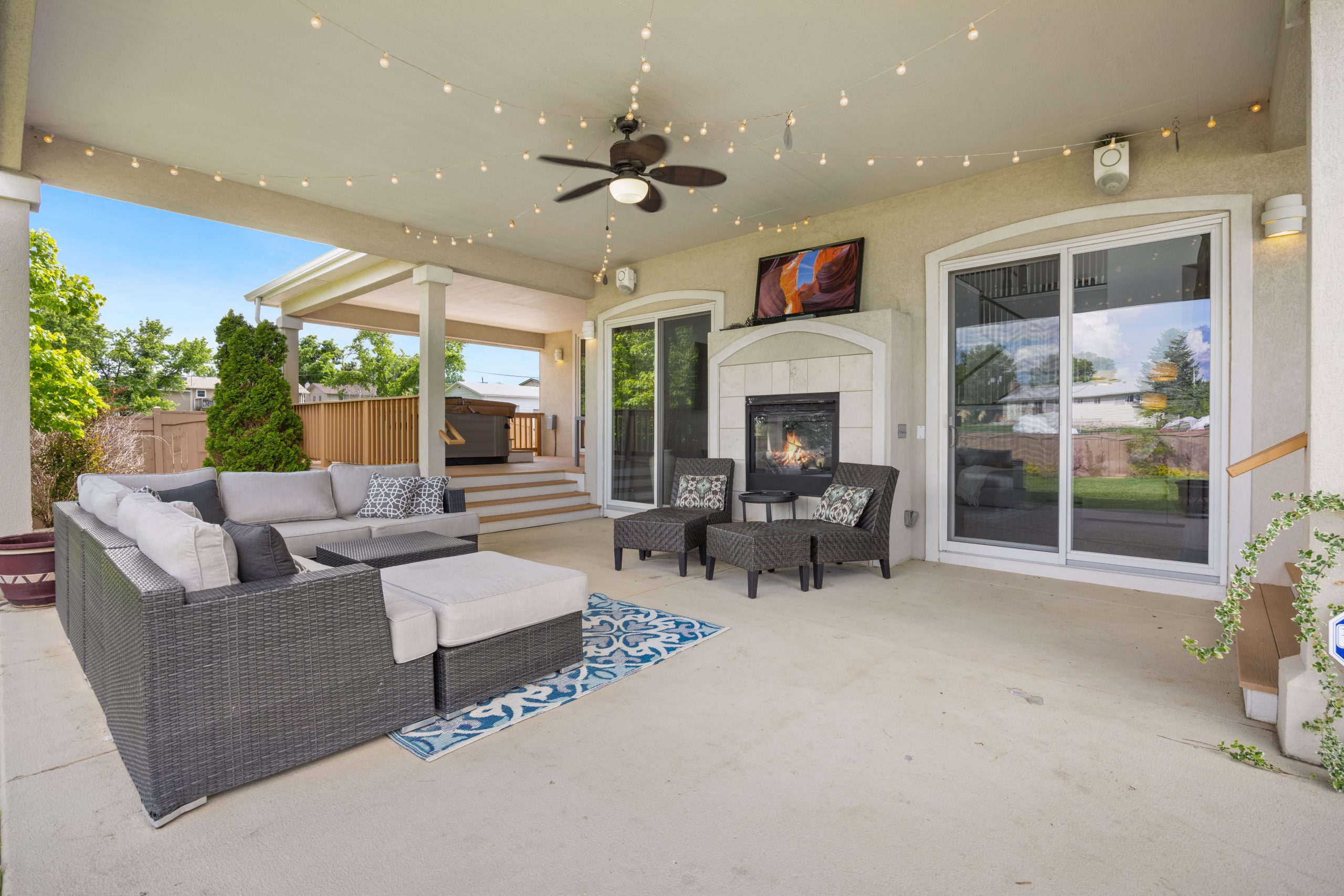 outdoor-music-patio-entertainment-area Outdoor patio with fireplace, comfortable seating, and string lights designed for evening music and entertaining.