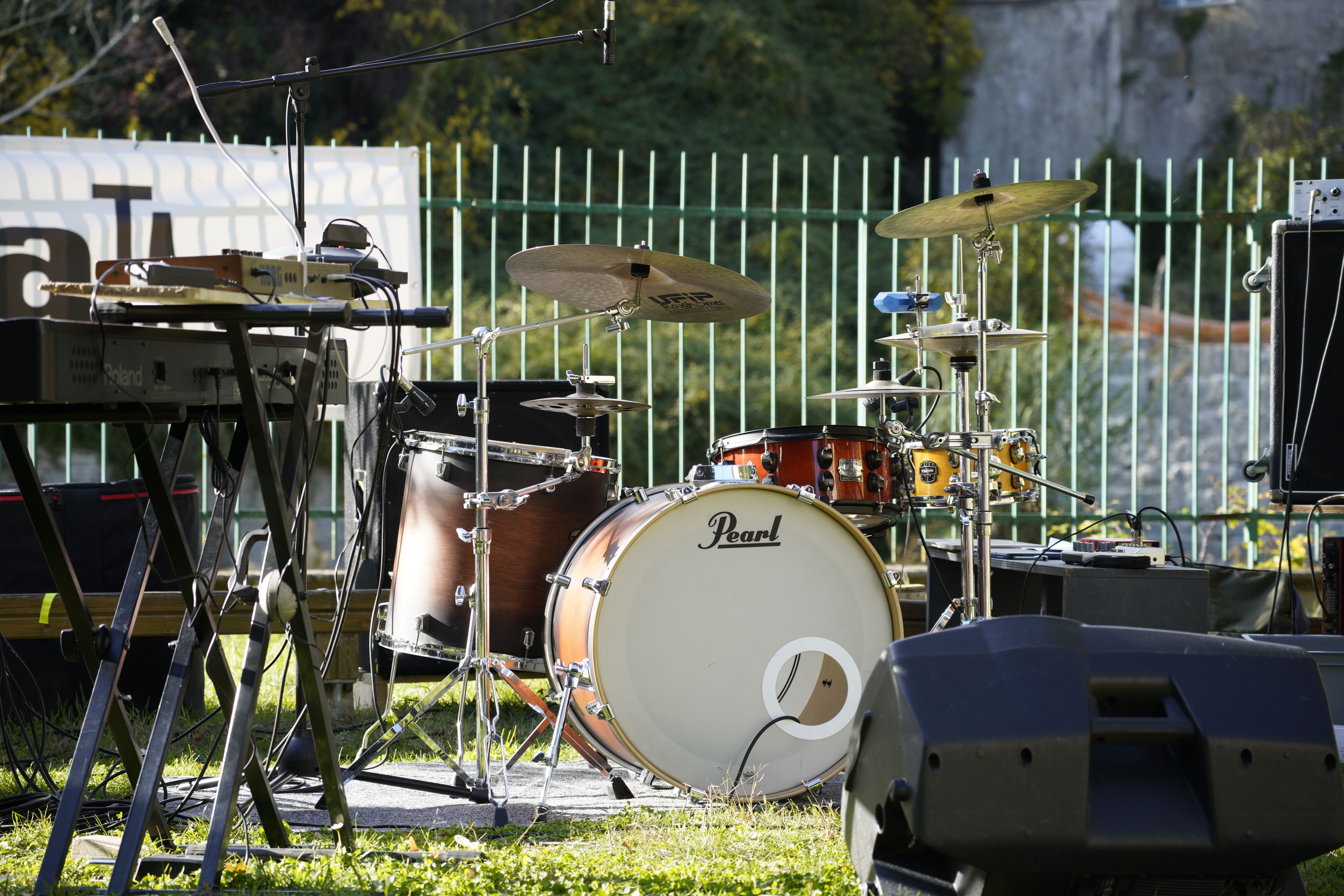 Outdoor music stage with drums and keyboard ready for a live performance.