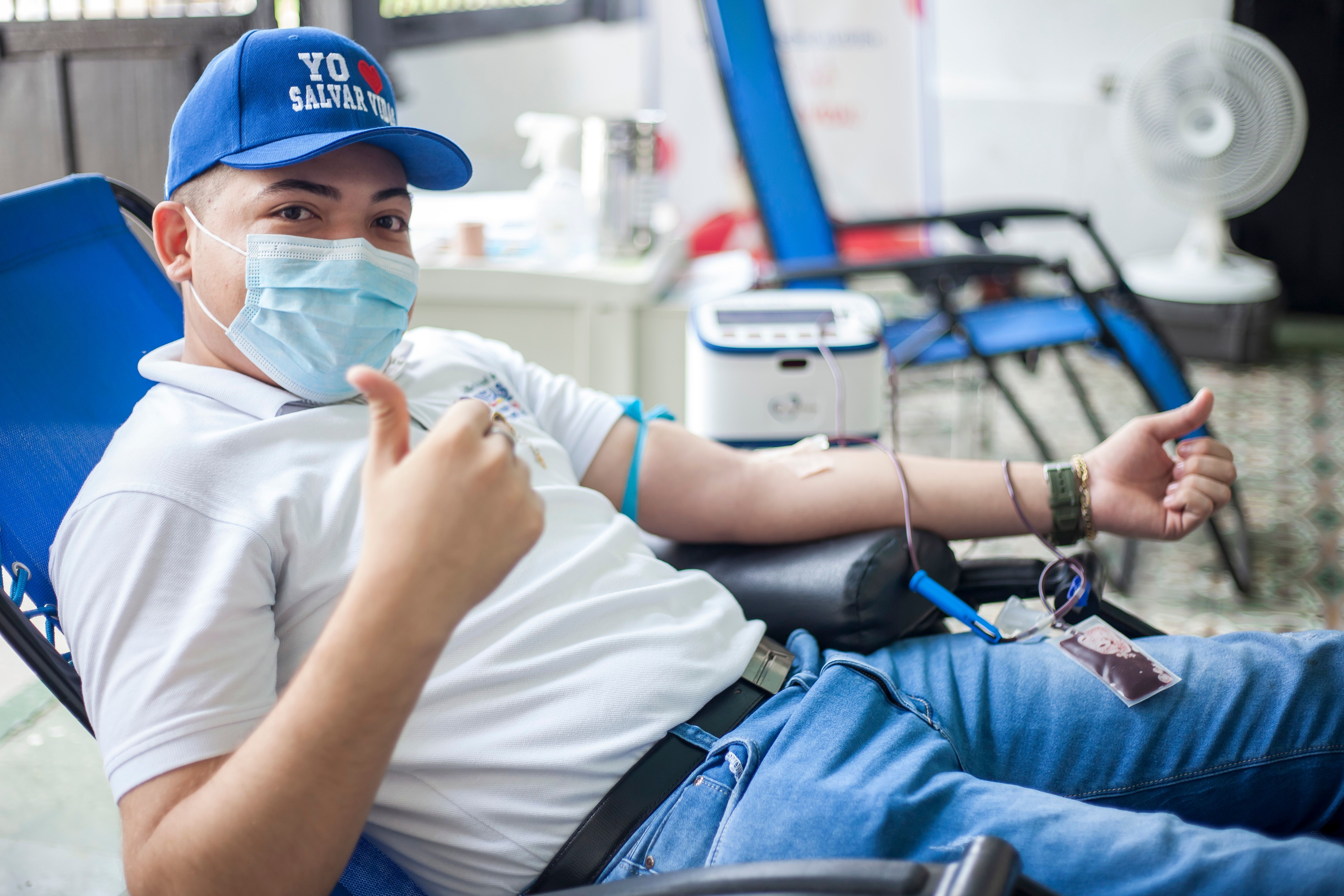 Donor gives a thumbs-up during a blood donation, offering a reassuring look at the appointment experience.