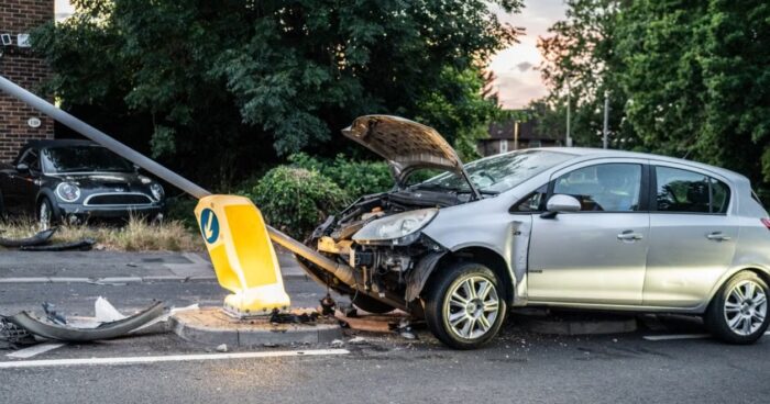 damaged car that crashed into a lamp post on a London street during twilight