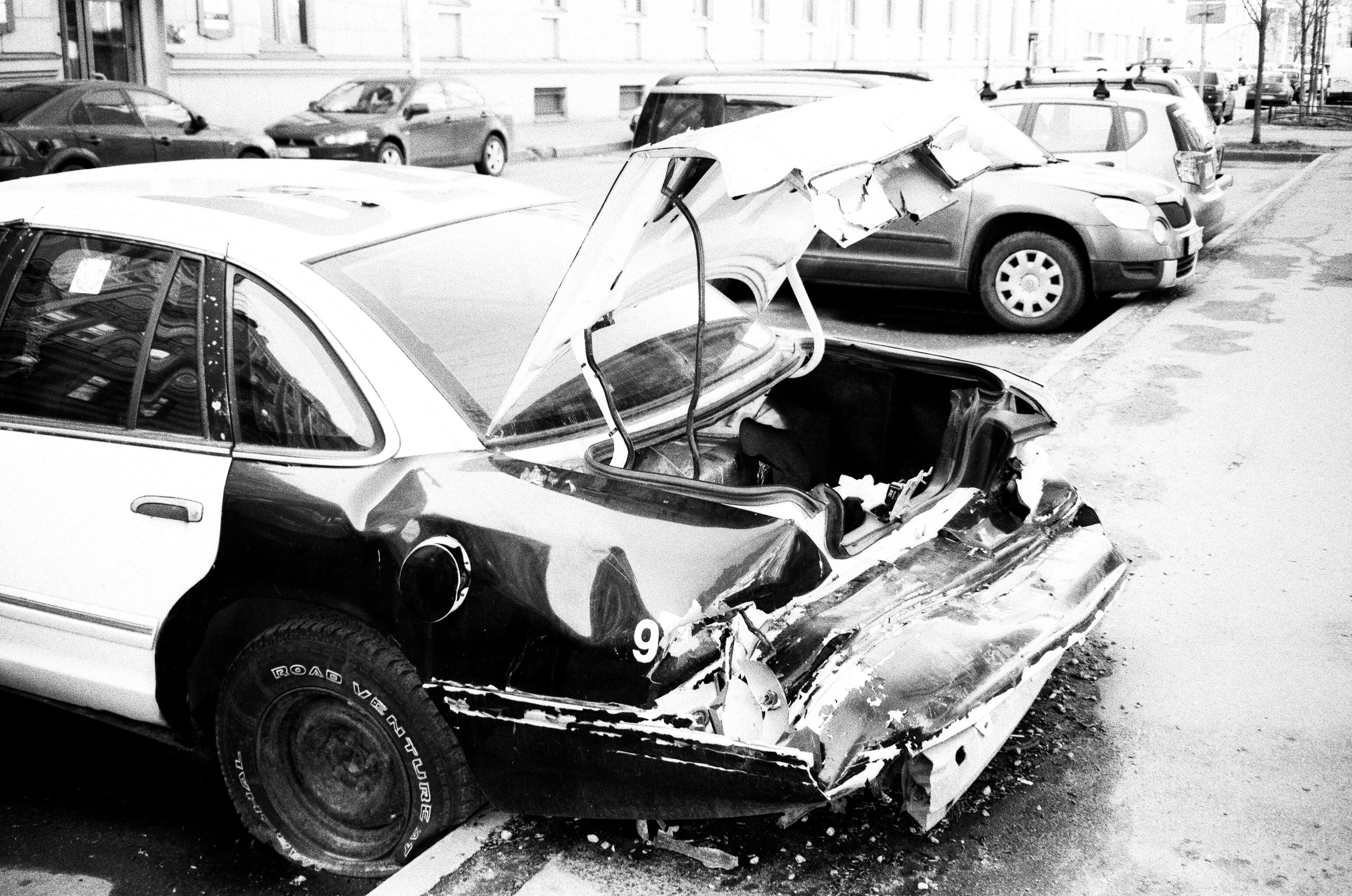 Damaged car on an urban street, representing the consequences captured in crash data.
