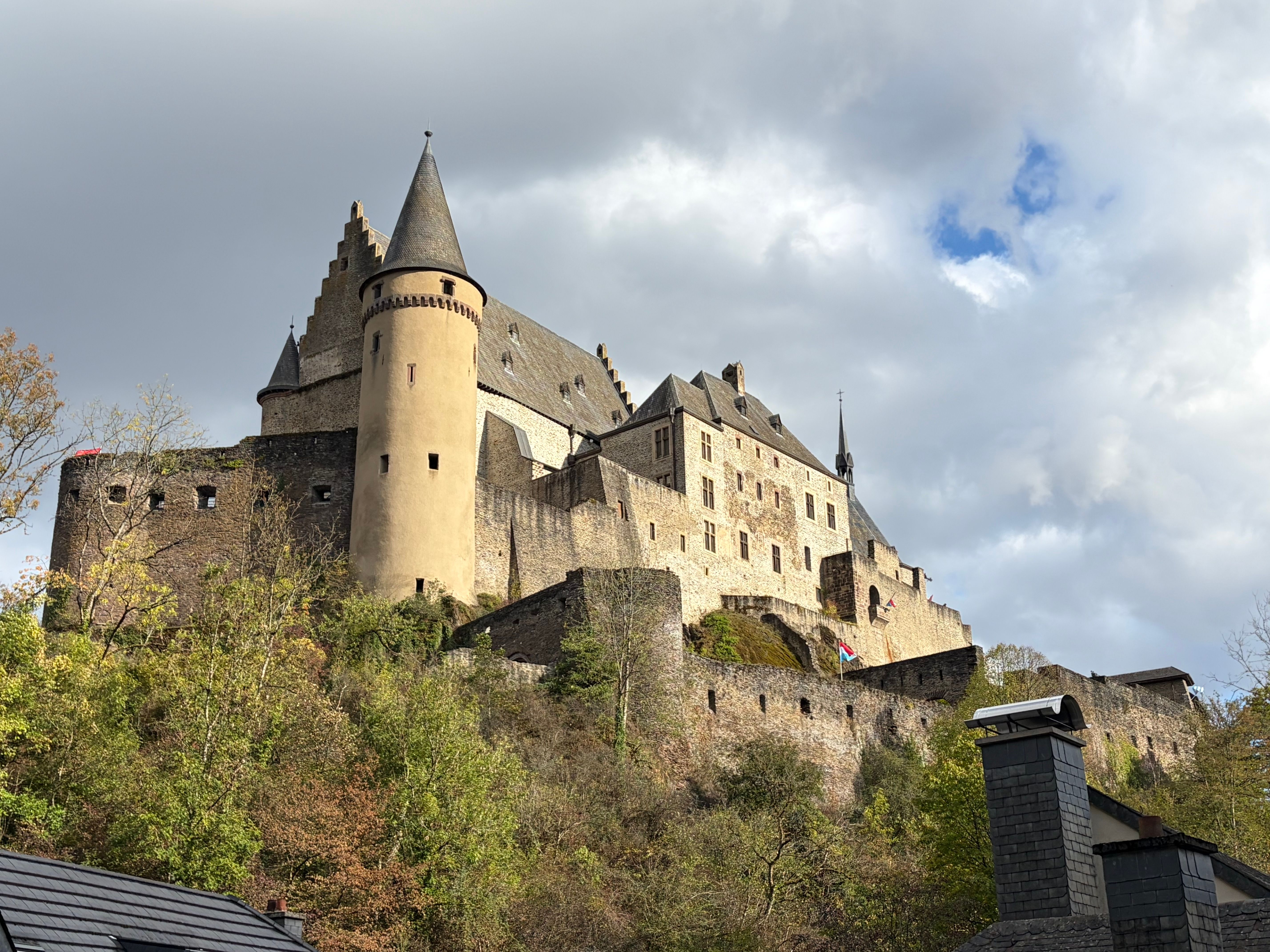 Vianden Castle in Luxembourg standing against a dramatic cloudy sky