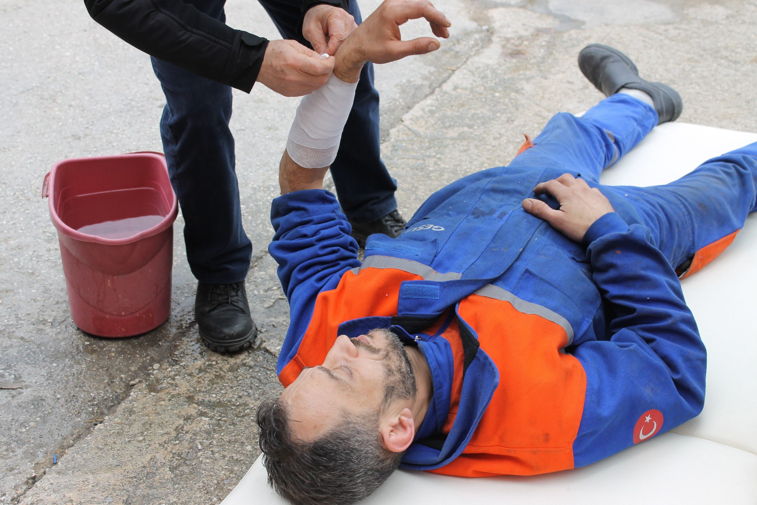Worker receives first aid for an arm injury at the worksite.