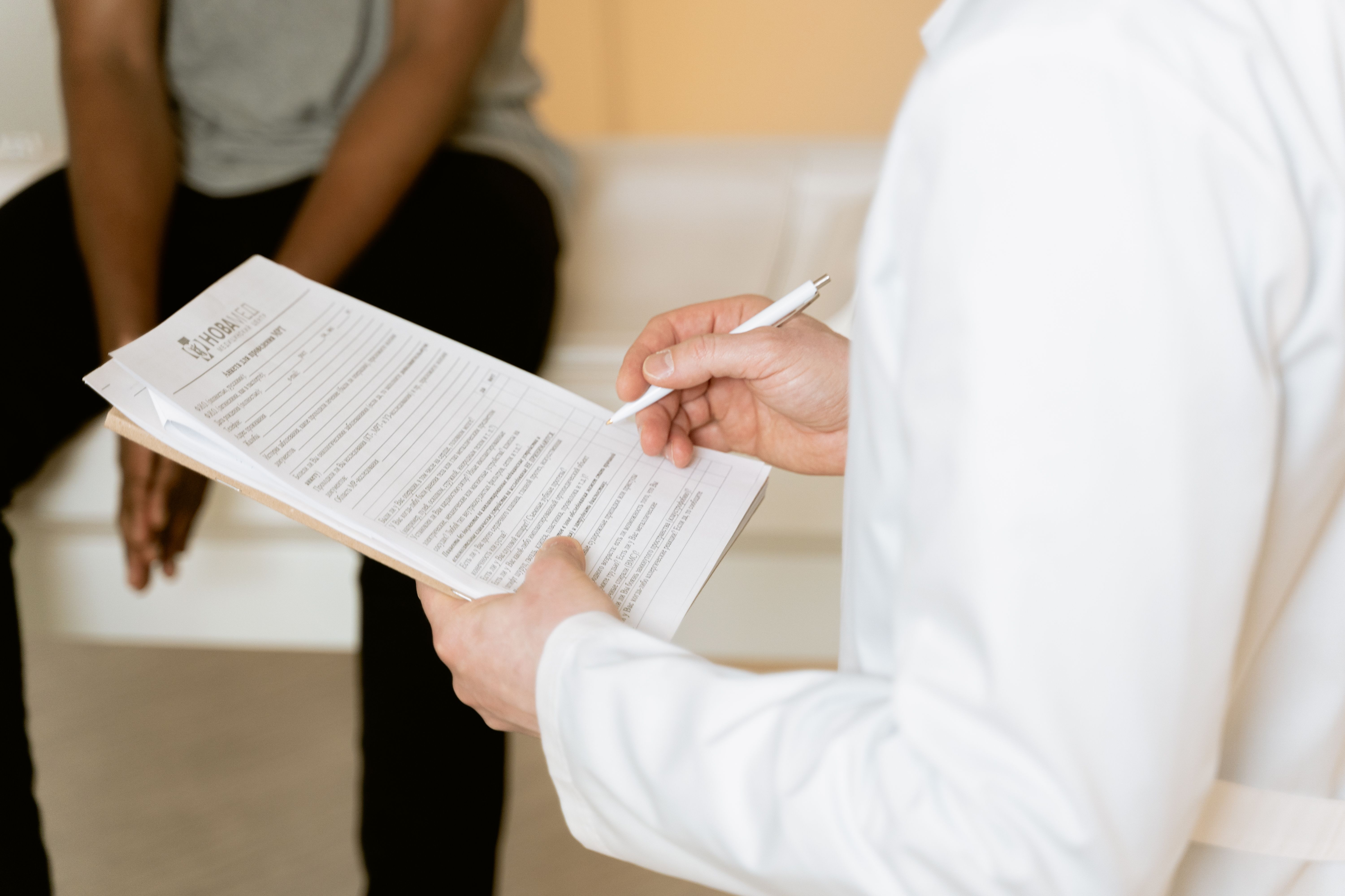Healthcare professional reviews a medical form with a patient during an injury consultation.