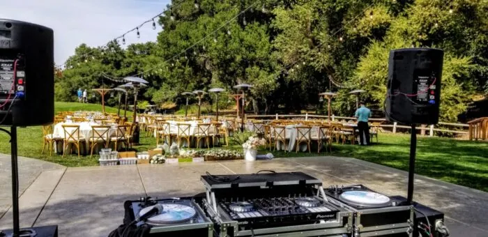 DJ setup with speakers, ‍mixer, and lighting
